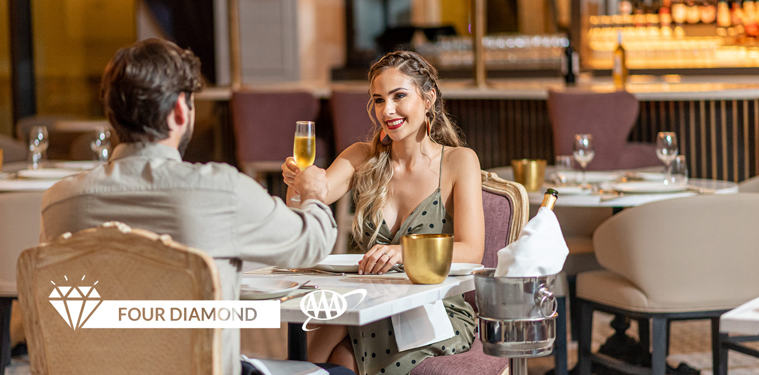  Couple toasting with champagne at La Boheme restaurant at the Lopesan Costa Bávaro Resort, Spa & Casino in Punta Cana, Dominican Republic 